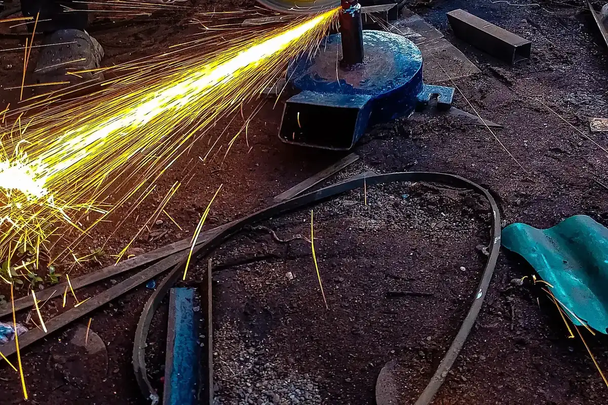 A close-up of an angle grinder throwing a shower of sparks in a workshop