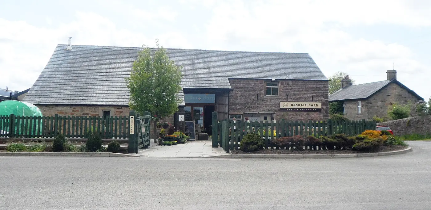 A large stone barn with a timber-clad extension, home to a craft brewery