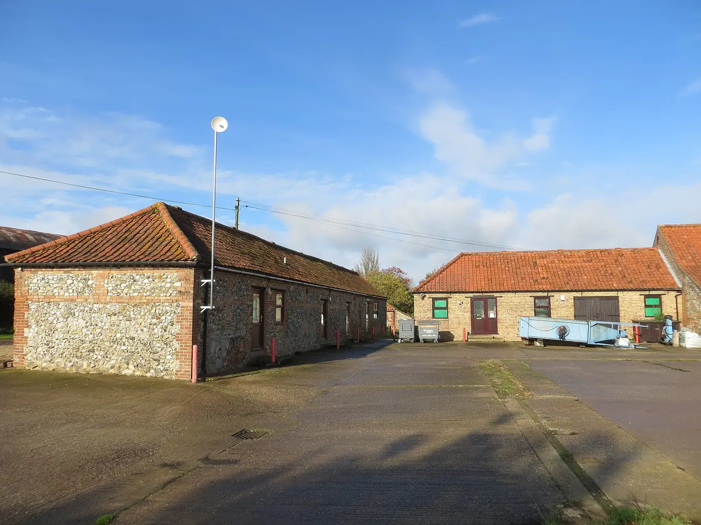 Two single-storey farm buildings converted into business units around a tarmac yard