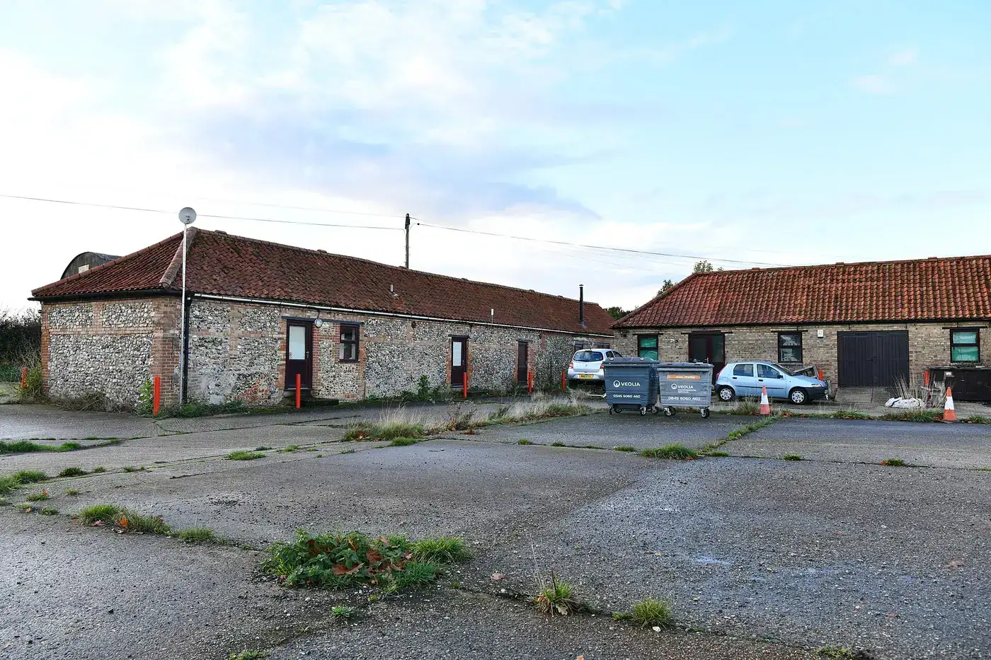 Converted flint and brick farm buildings let as business units around a yard