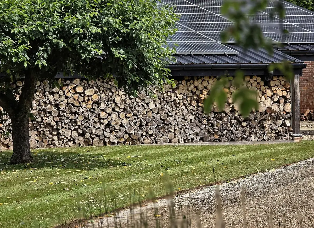 A large open-fronted barn stacked high with split logs