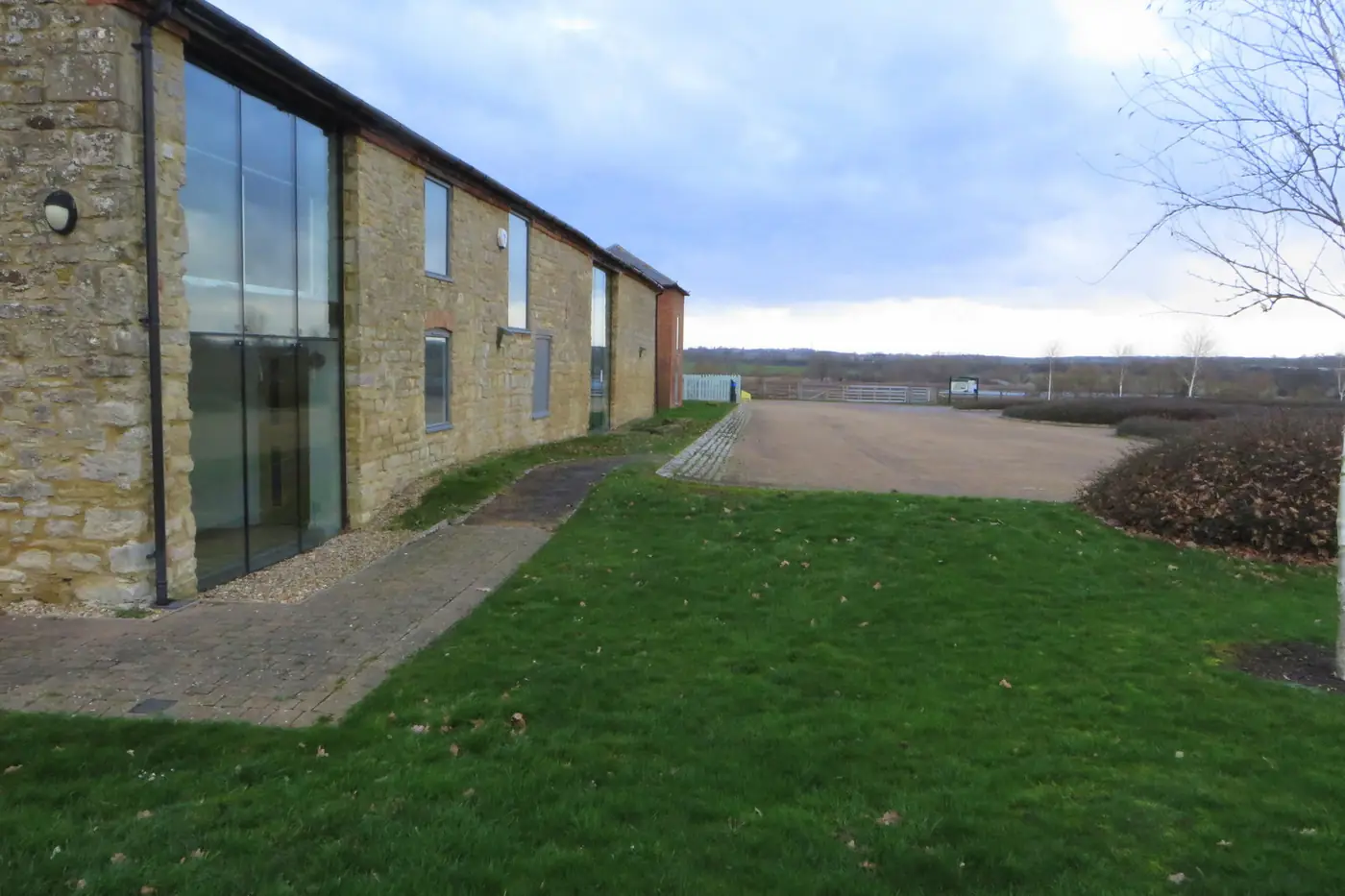 A brick and tile farm building converted into business units with a large glazed entrance