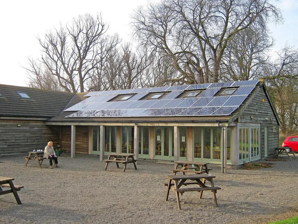 Solar panels on the roof of a farm shop building with outdoor seating in front
